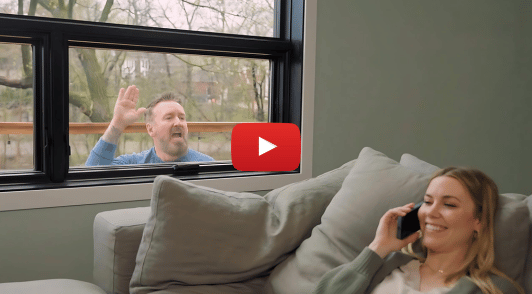 comedian outside waving to human through the window