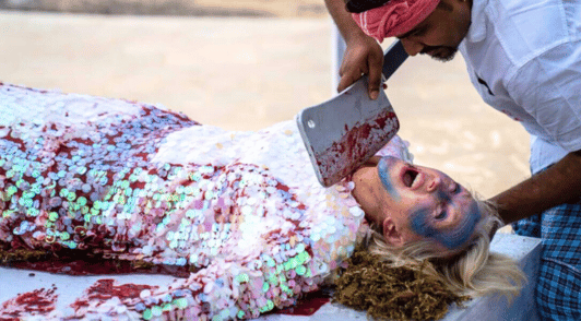Ingrid Newkirk dressed as a fish getting chopped up