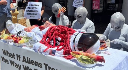 demo of people dressed as aliens eating an astronaut