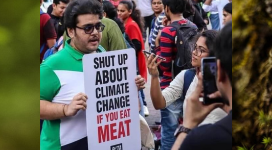 image of protester holding sign reading shut up about climate change if you eat meat 