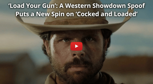 man wearing a hat with the words load your gun a western showdown spoof puts a new spin on cocked and loaded