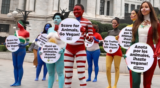 body painted animal defenders with signs saying to go vegan