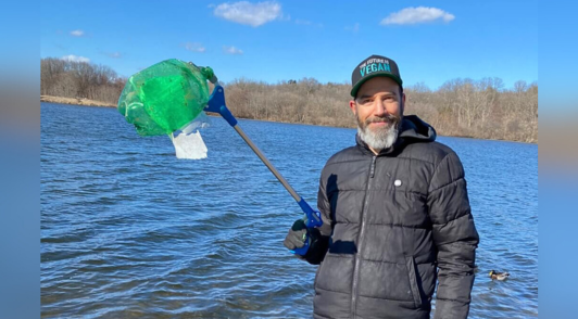 man fishing for trash in water