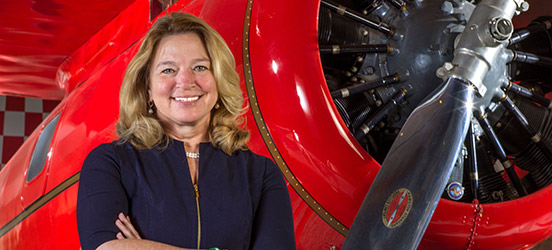 The Director of the Air and Space Museum stands in front of a red airplane.