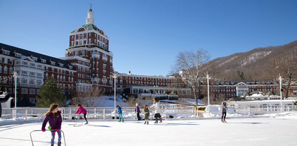 ice rink with hotel and mountains in background