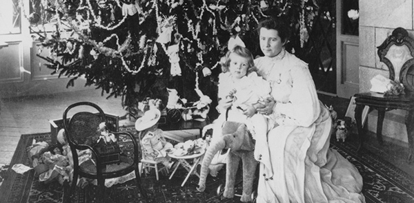 b&w photo of a seated woman and child in front of a Christmas tree