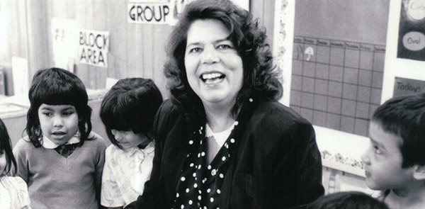 Woman looking at the camera with three children around her