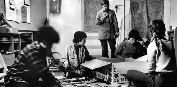B&W photo of women gathered around a cardboard box