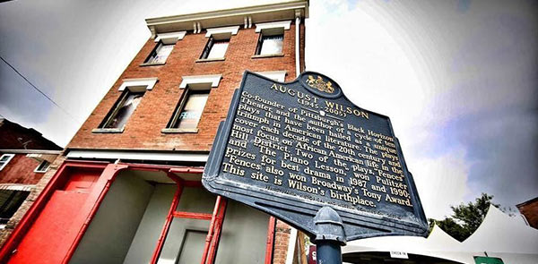 August Wilson historical marker in front of a three story brick building