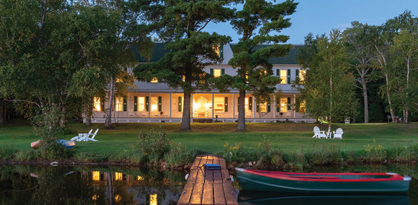 building by water at night with a canoe out front