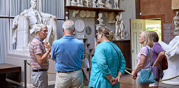 People talking in front of a Lincoln sculpture