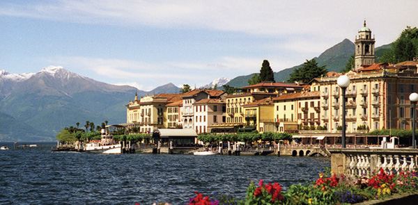 Builiding on the side of a lake with mountains in the background