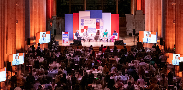 A panel of five people on a stage in the National Cathedral. David Keith Photography.