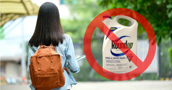 college university student with a backpack next to a bottle of Monsantos glyphosate herbicide ROUNDUP with a red circle and slash through it