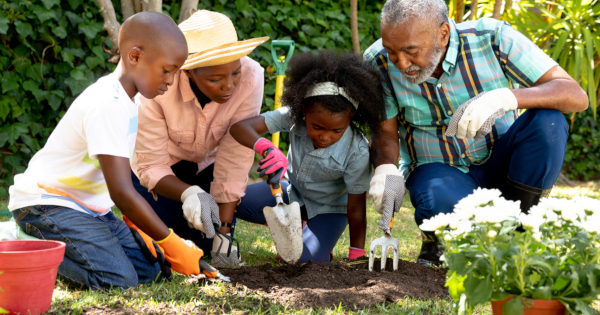 grandparents and children gardening in the soil