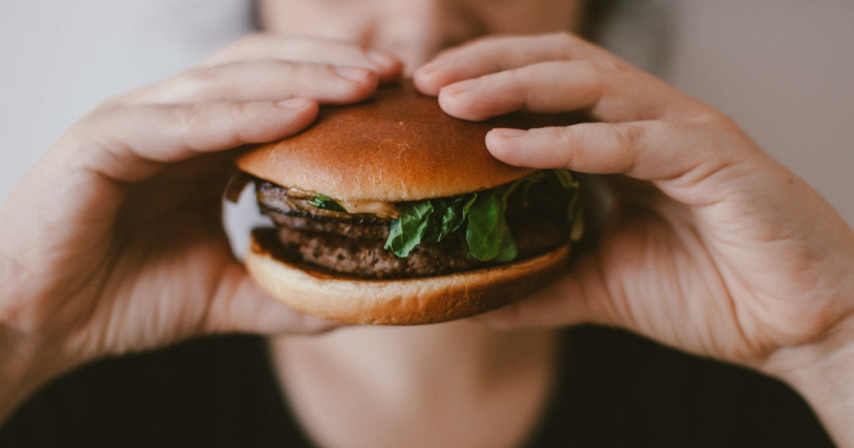 man eating a hamburger on a bun