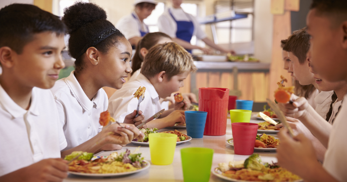 school children eating healthy food in a cafeteria