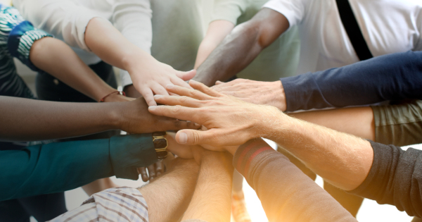 several people joining hands together in teamwork