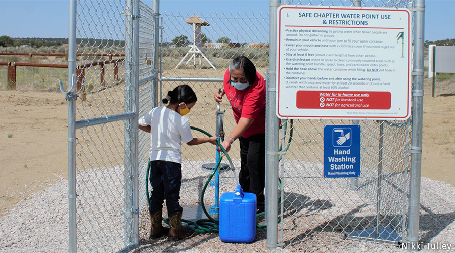 A family collects water from a designated safe water point