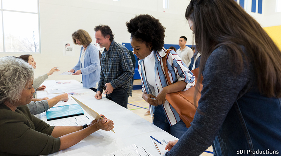 Voters collect their ballots from election workers at their voting site