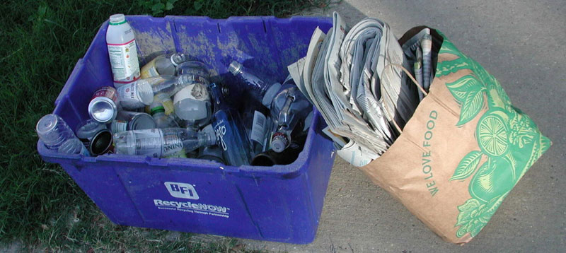 recycling bins filled with bottles and newspaper