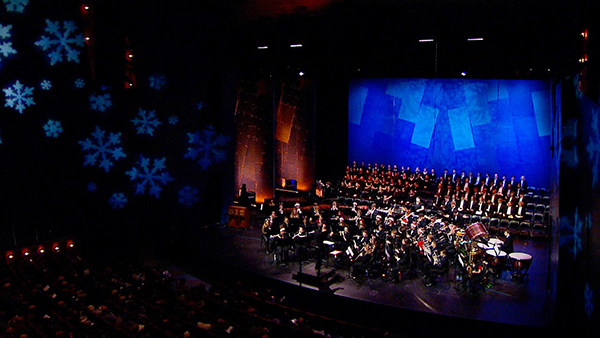 An orchestra performs on stage in a concert hall in Eau Claire, Wis.