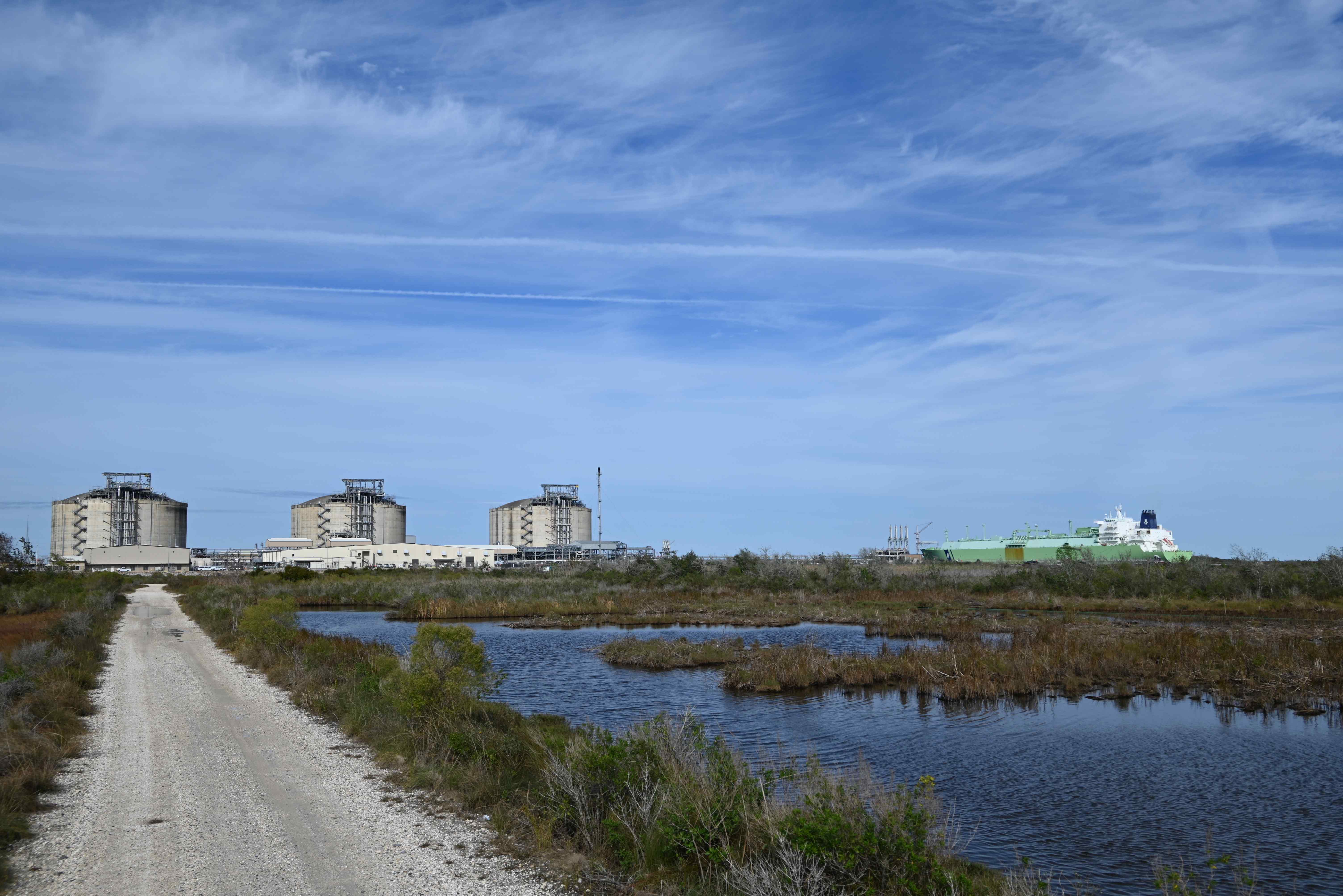 Cameron LNG tanks stand in the background of lush wetlands