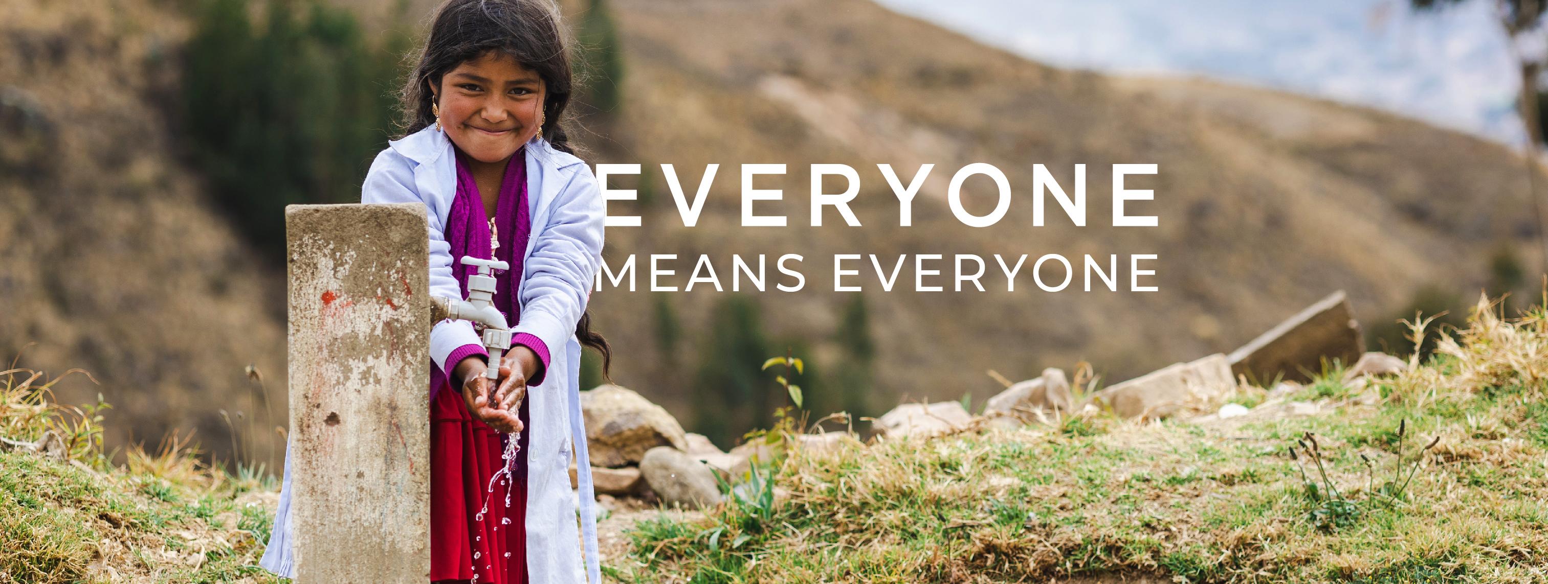 A young girl washes her hands at a tap with mountains in the background. Text over the image says Everyone Means Everyone