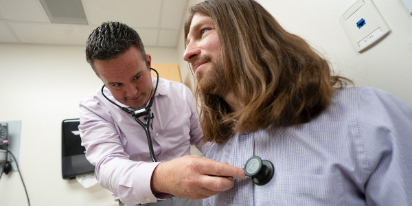 Doctor using a stethoscope to listen to his patient's heart