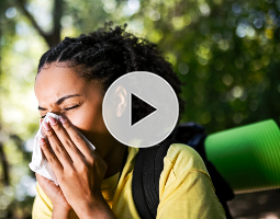 Woman sneezing outdoors
