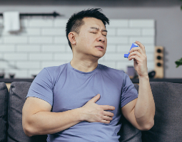 Man with asthma using an inhaler