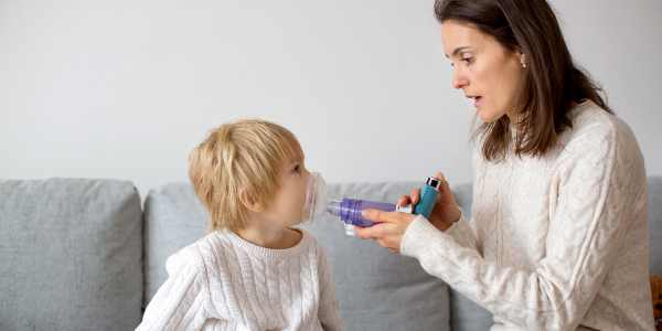 Mother helping her son with an inhaler