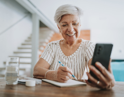 Patient using a smartphone and taking notes.