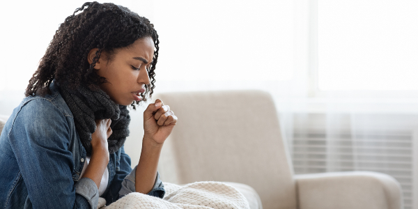 Woman coughing while holding her chest