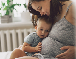 Pregnant woman holding a young child, representing maternal heart health during pregnancy.