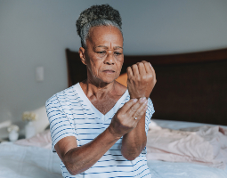Woman experiencing wrist pain, a common early warning sign of rheumatoid arthritis.