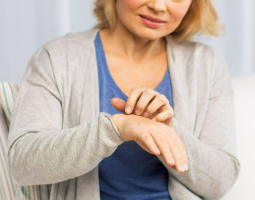 A woman scratching the skin on her wrist.