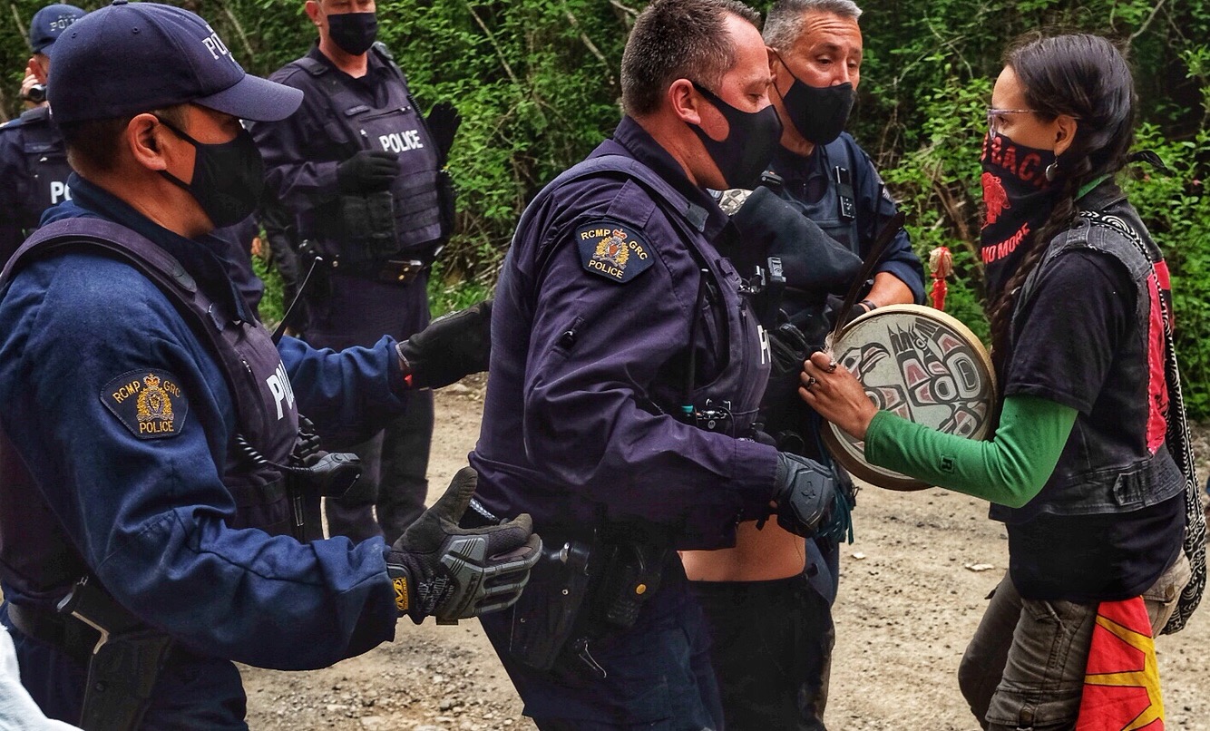 RCMP confronting an Indigenous woman at Ada'itsx/Fairy Creek