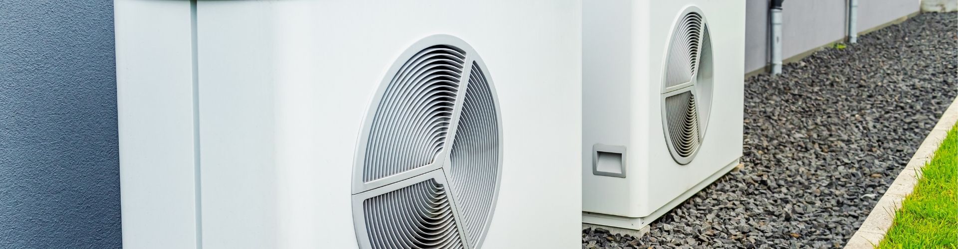 two heat pumps against a wall