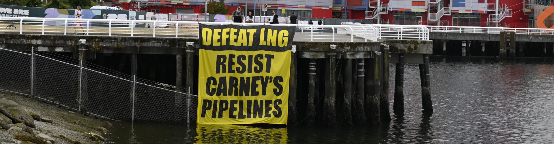 Banner on pier reading: Defeat LNG, Resist Carney's Pipelines