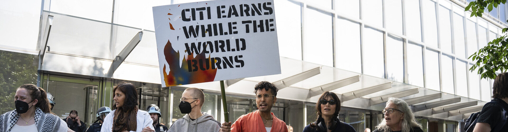 Photo of Summer of Heat Costco protestors with a sign that call for an end to Citi's fossil fuel financing.