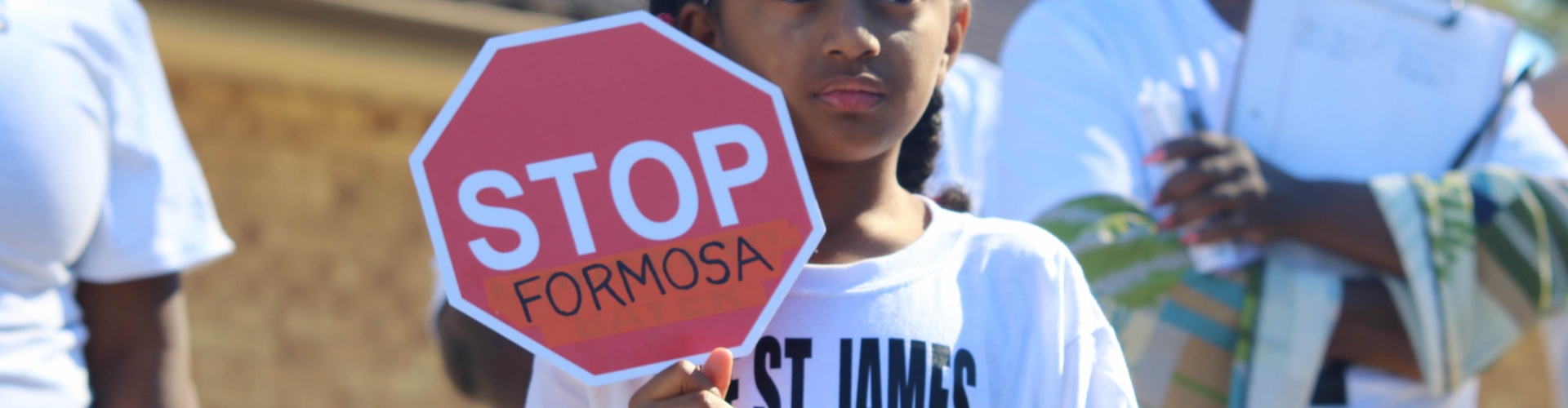 Photo of child holding a sign saying "Stop Formosa" to protest Citi potential financing of a $12 billion petrochemical plant in St. James Parish, Louisiana.