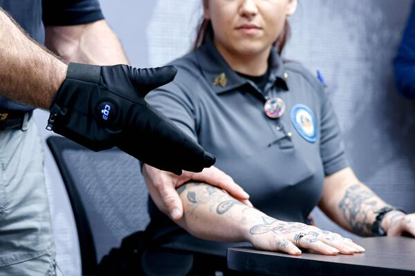 Someone about to demonstrate a shock glove's effect on a volunteer