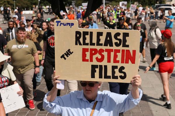 Protester with sign about Epstein files