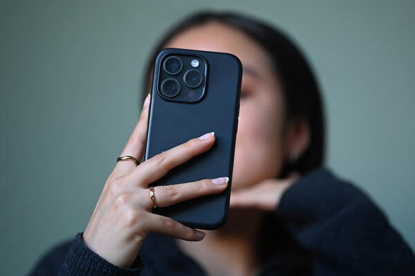 Person holding phone in front of face