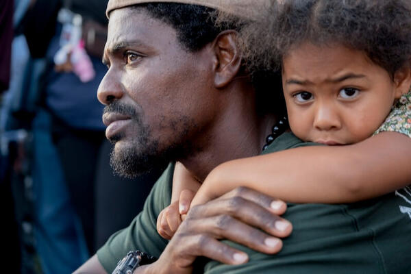 A man holds a child on his back during a vigil near the Islamic Center of San Diego, California (05/17/2026)