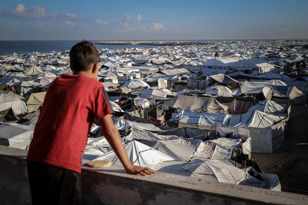 A boy looks out over a sea of tents in Gaza City