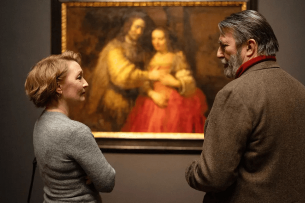 Stella & Gerry in front of a painting depicting the 