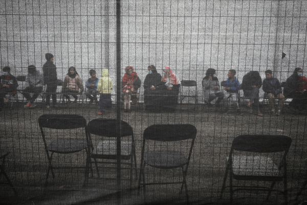 Afghan refugees queue outside a distribution and donation center