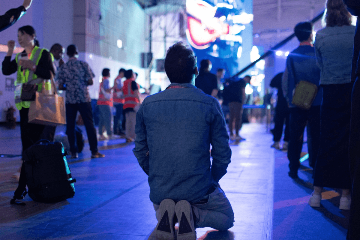 Man kneels surrounded by blue light